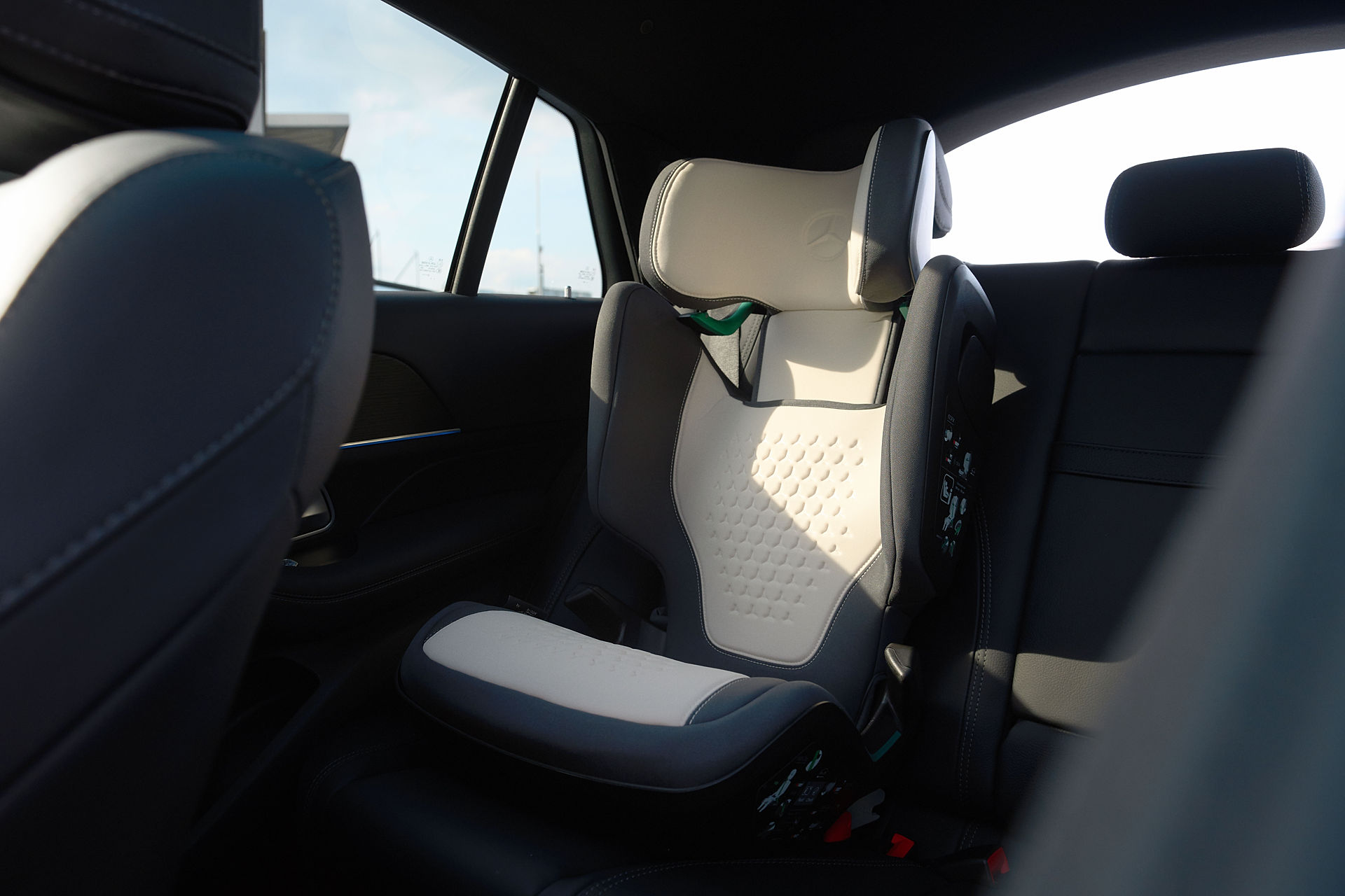 Abgebildet wird der Mercedes-Benz Kindersitz KIDFIX mit der Teilenummer A0009708902 in schwarz beige. Der Sitz ist in einem Fahrzeug eingebaut.