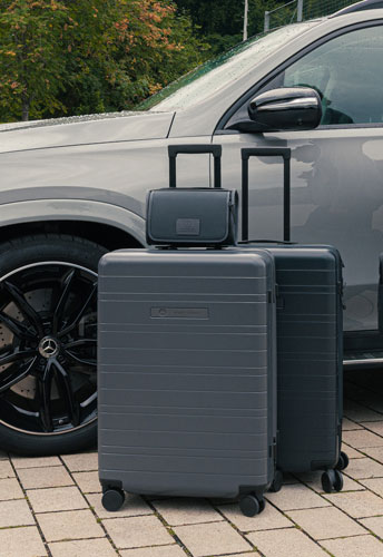 Abgebildet sind 2 Koffer der Mercedes X HORIZN STUDIOS Koffer. Diese stehen vor einem grauen Mercedes-Benz Fahrzeug.