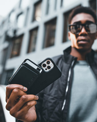 Mann hält Kartenetui und Handyhülle B67960002 von Mercedes-Benz in die Kamera. Verlinkt auf die Kategorie: Handyhüllen. 