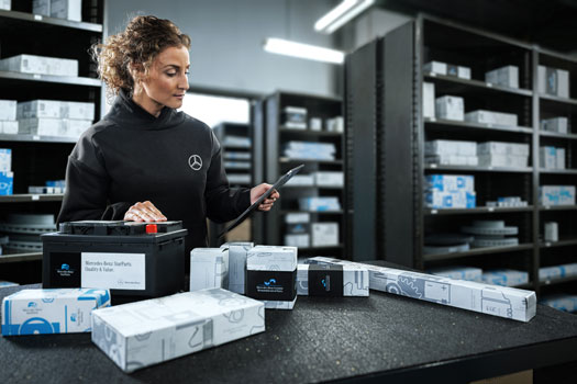 Mercedes Teile liegen vor einer Frau auf dem Tisch, die diese prüft